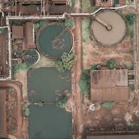 From above aerial view of industrial area of sewage treatment plant with round shaped water clarifiers