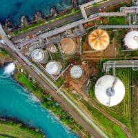 Aerial view of an industrial complex near a river in Banten, Indonesia, showcasing storage tanks.